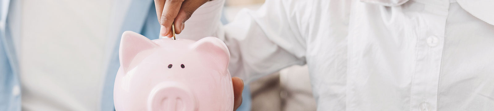 Child putting coin into piggy bank